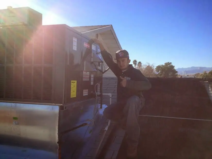HVAC technician performing AC Tune-Up on a rooftop unit in Kendallville